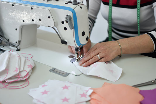 Woman sewing homemade face mask out of sheet